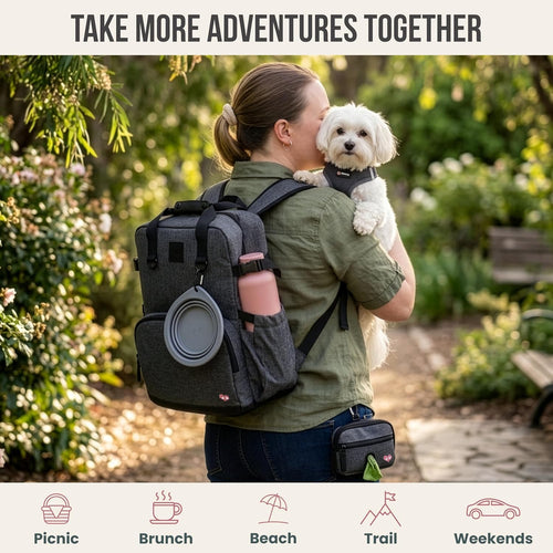 A woman carrying a small white dog while wearing a gray dog travel backpack on a outdoor trail.
