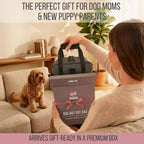 A woman unboxing a gray dog travel backpack from a branded gift box while a fluffy dog watches from the couch.